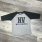 Gray and black baseball shirt with 'NV Wolverines' text on a wooden floor.