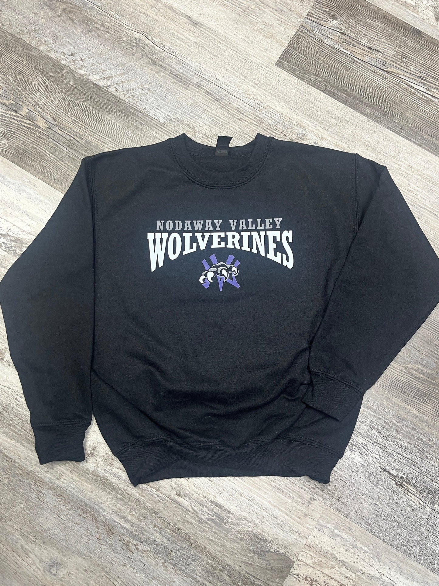 Black sweatshirt with 'Wolverine Nodaway Valley' text on a wooden floor