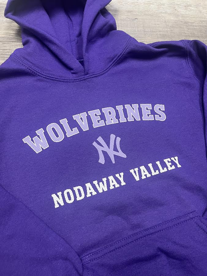 Purple hoodie with 'Wolverines Nodaway Valley' text on a wooden surface