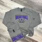 Gray long-sleeve shirt with 'Nodaway Valley Basketball' text on a wooden surface