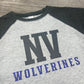 Gray and black baseball shirt with 'NV Wolverines' text on a wooden surface